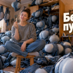 Процесс ушивки талии джинсов вручную с закреплёнными булавками складками на поясе для устранения пузыря сзади