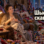 Женщина шьёт вечером за столом в гостиной, рядом сидят члены семьи, атмосфера спокойного диалога дома